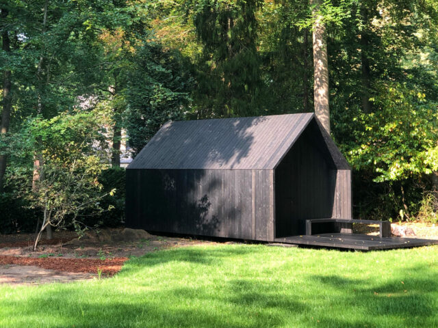 minimalistische zwarte tuinberging of houten bijgebouw in een tuin